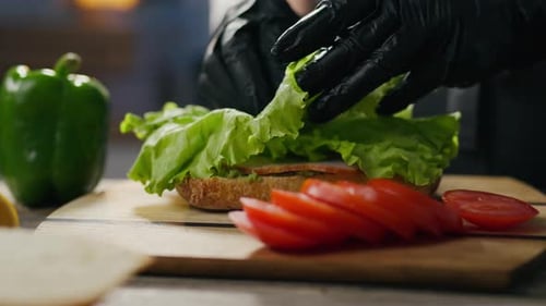 Gloved Hands Preparing a Delicious Sandwich
