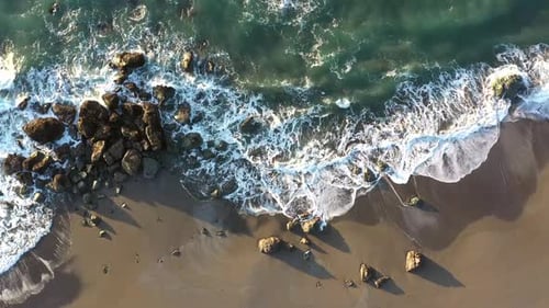 Aerial View of Waves Crashing on Sandy Beach