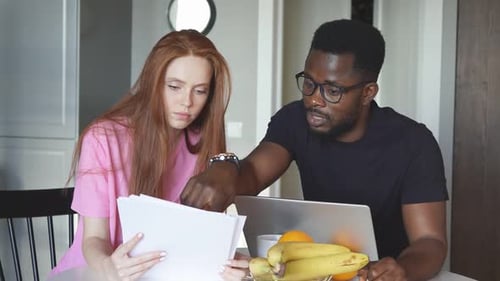 Woman and Man Looking at Papers at Table