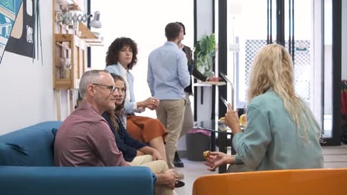 Business Colleagues Having Conversation During Break in Office Canteen