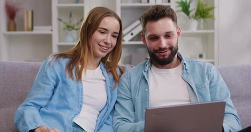 Couple Enjoying Laptop Together on Cozy Sofa