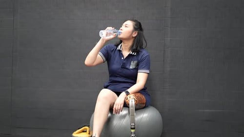 Woman with Prosthetic Leg Drinking Water at Gym