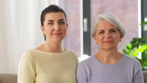 Smiling woman hugging senior woman at home