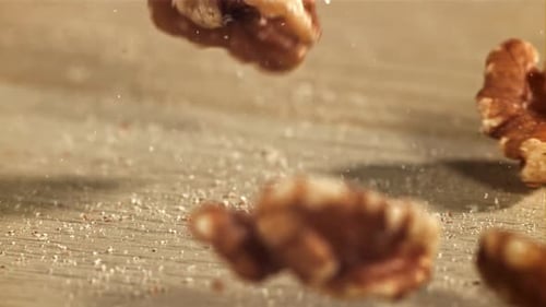 Walnuts Falling on Wood Surface in Slow Motion