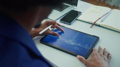 Architekt untersucht Gebäudeplan auf Tablet-PC