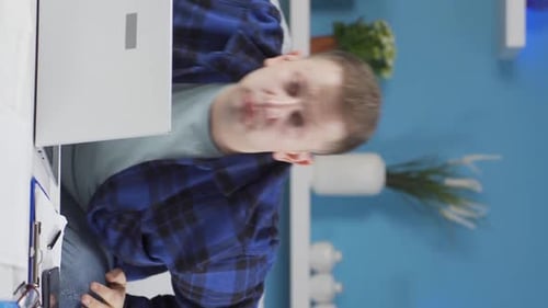 Vertical video of Home office worker man looking at camera curious and confused.