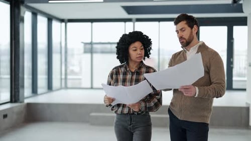 Business Colleagues Discuss Blueprints for a New Project in a Modern Office