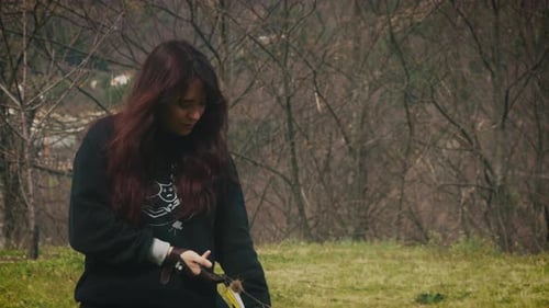 Young woman pulls an arrow from a bow and prepares to shoot