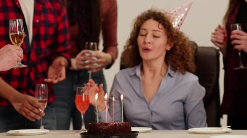 An Office Worker Celebrates His Birthday with His Colleagues A Curlyhaired Woman in a Festive Cap