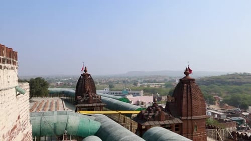ancien temple hindou avec drapeau sacré agitant et fond de ville brumeuse, vidéo prise le matin