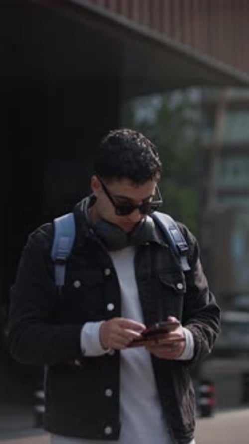 Portrait of Latin Male Traveler Checking Mobile Phone in City