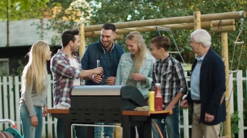 Group of Mixed Race People are Gathering around the Grill on Backyard before Family Dinner.