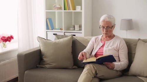 Age, Leisure and People Concept - Senior Woman in Glasses Reading Book