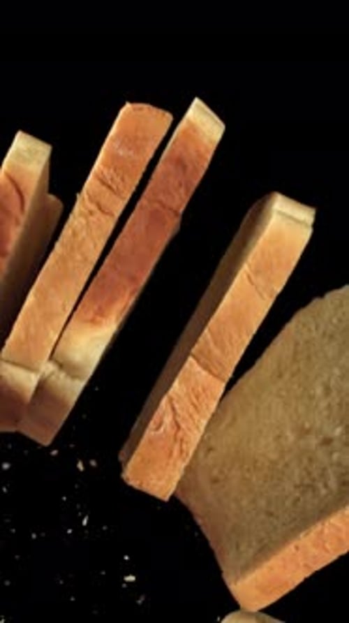 Pieces of Fresh Bread Fly Up Against a Black Background Filmed on a Highspeed Camera at 1000 Fps