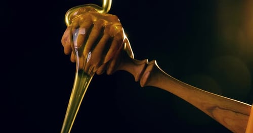 Golden Honey Dripping from Wooden Honey Dipper