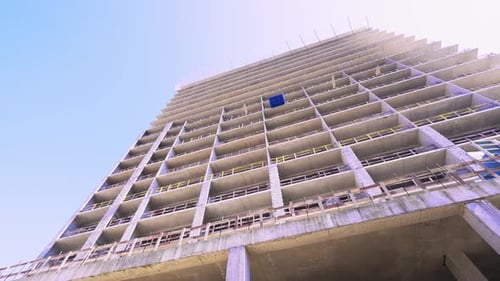 Casa grande y alta sin terminar contra el cielo azul.