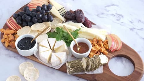 Different types of cheese board with fruits and crackers.
