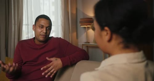 Man Conversing with Woman in Indoor Setting