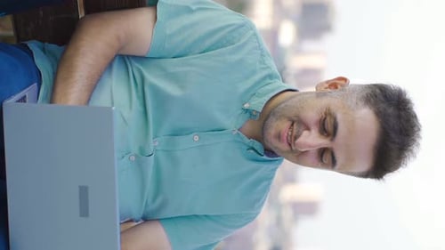 Man Works on Laptop in Vertical Video Format