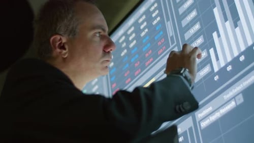 Serious Man Writing Data on Tablet From Digital Screen