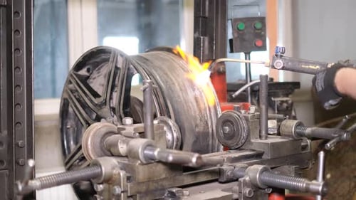A Car Mechanic Aligns Car Rims with a Welding Machine