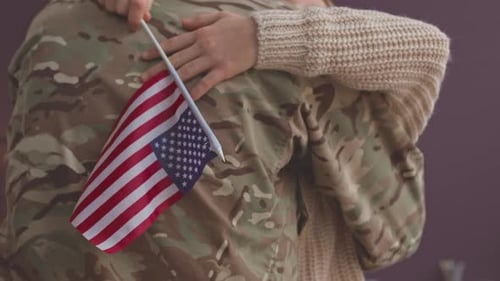 Child Embraces Soldier With American Flag
