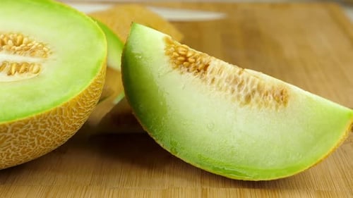 Tracking-Aufnahme einer geschnittenen Galia-Melone auf einem Schneidebrett