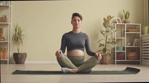 Pregnant Woman Meditating Calmly on Yoga Mat
