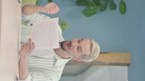 Man Reading Document and Celebrating Good News