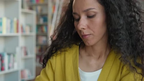 Young Woman Studying in a Library Writing