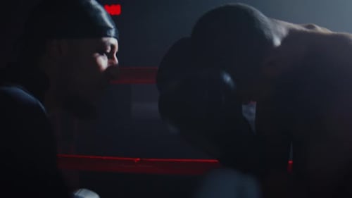 Men Boxing in a Dimly Lit Sparring Ring