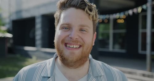 Slow Motion of Happy Man Laughing Having Fun Standing Outdoors in City and Looking at Camera