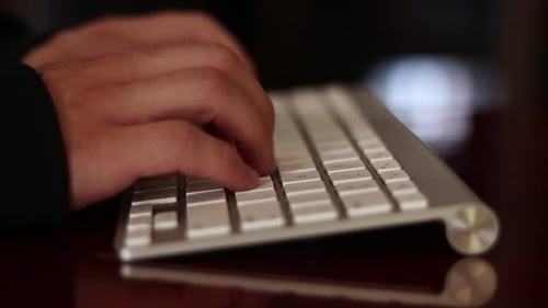 Manos masculinas escriben en un teclado