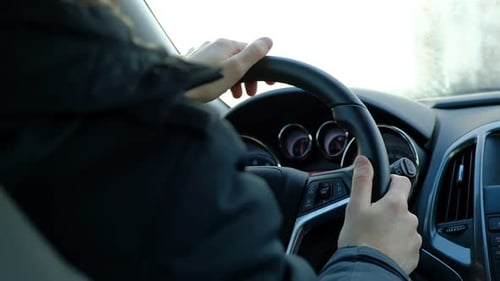 Closeup of Person Hands on Steering Wheel Driving Car Man Driving a Vehicle Slowmotion