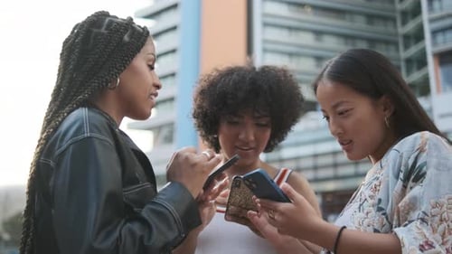 Three Friends Using Smartphones in an Urban Setting