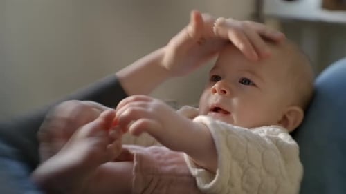 Adorable Baby Lying On Mother's Lap. Close-up Shot