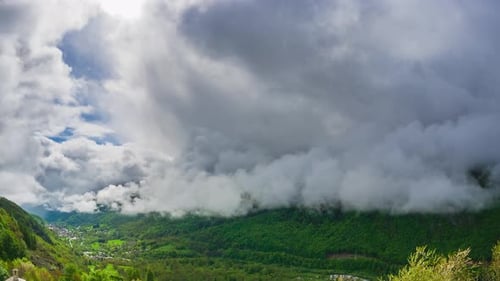 Zeitraffer: Alpen, Italien, Bergwaldkamm unter weitem Himmel mit dramatisch Cumulu
