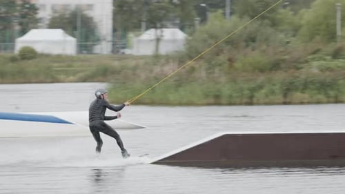 Wakeboard Rider Sliding on Slider in Cable Park