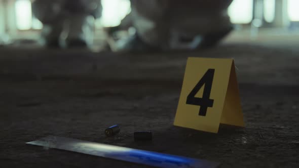 Yellow Forensic Marker and Ruler next to Used Bullets at Murder Scene ...