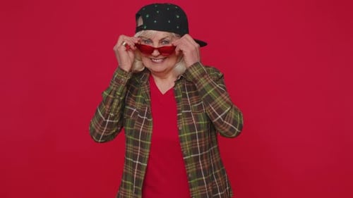 Smiling Senior Woman Removing Red Sunglasses