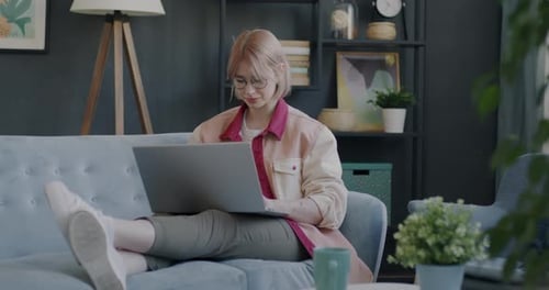 Woman Using Laptop Relaxing on Couch
