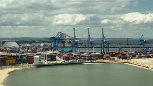 Aerial of the Gdańsk harbor, featuring a busy container port with numerous colorful shipping contain