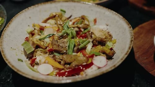 Salteado gourmet de verduras con champiñones en un tazón de cerámica sobre mesa negra