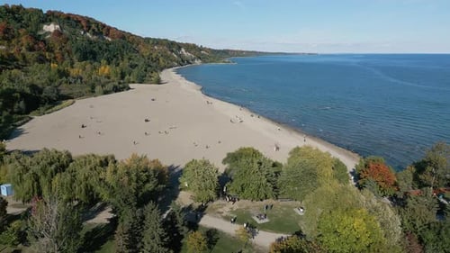 A drone shot of a nearly empty beach on a clear sunny day, Bluffers Park and Beach in Ontario Canada