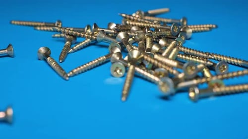 Collection of Shiny Screws on a Blue Background