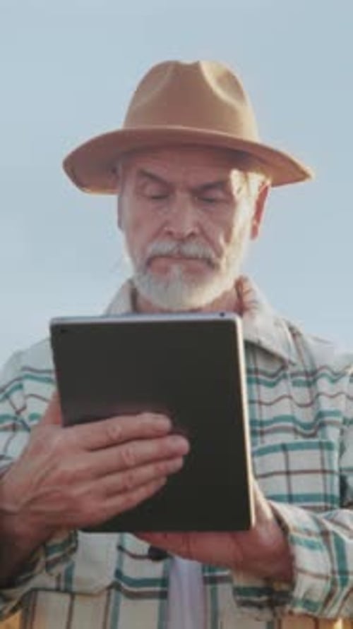 Senior Man Outdoors Using a Tablet Device