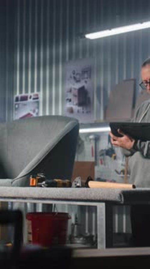 Man Using Tablet at Furniture Repair Workshop