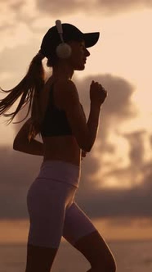 Woman Running on Beach During Sunrise Silhouette