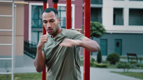 Muscular Man Shadow Boxing Outdoors in the City