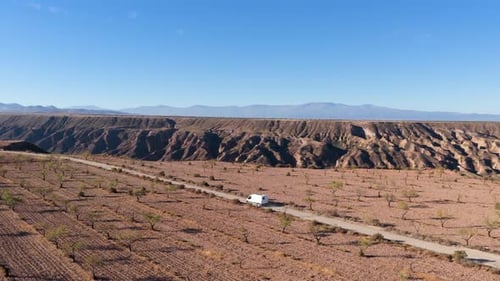 White Camper Van Driving Through the Gorafe Desert in Spain